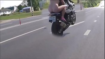 Naked girl rides a city on a motorcycle